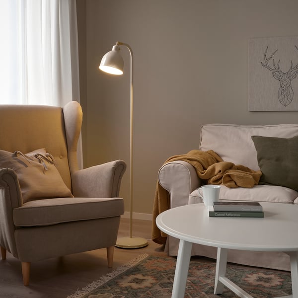 Cosy living room with RÖDFLIK lamp, grey armchair, and green-pillowed sofa.