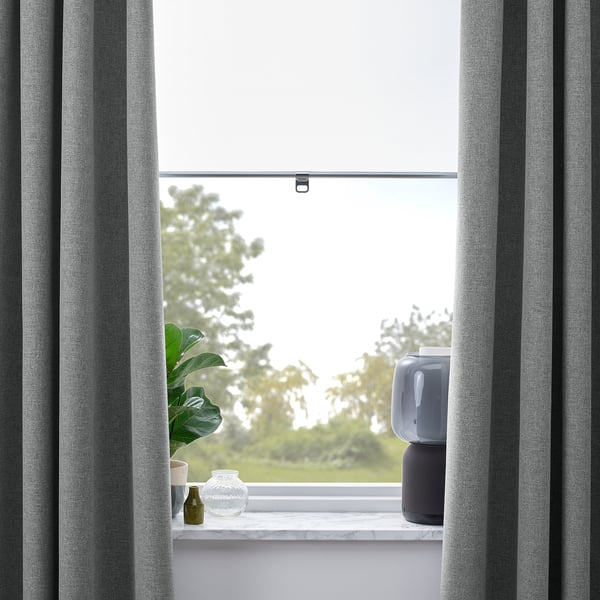 Window with grey curtains, open at top. On sill, plant, vase, and lamp.