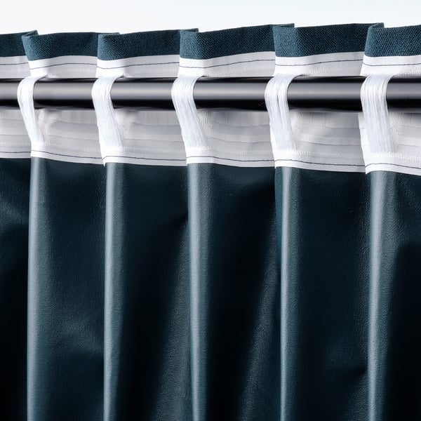 Close-up of dark blue curtains with white tape and rod pocket, designed for room darkening and easy hanging.