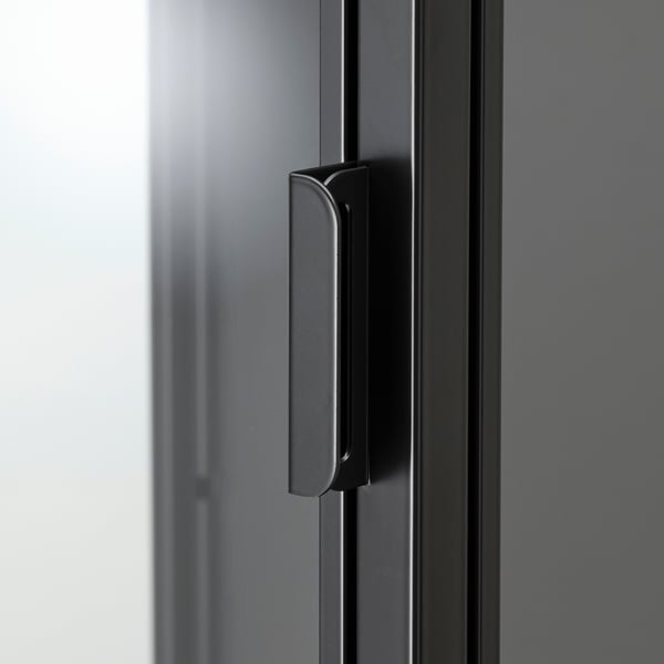 Black metal handle on sleek glass cabinet door; smooth, modern finish.