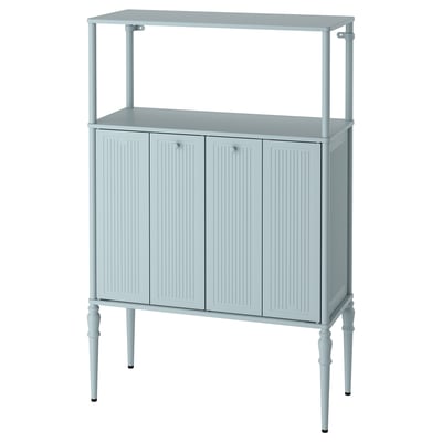 Displays a light blue SÅGMÄSTARE cabinet with rounded corners, bi-fold doors, and turned legs, offering storage with a traditional style.