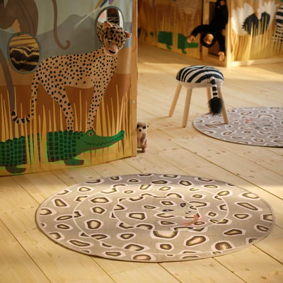 Circular rug, sand-colored with snake pattern. A coiled snake graphic, rubber backing for grip. Neutral tones, cotton material.