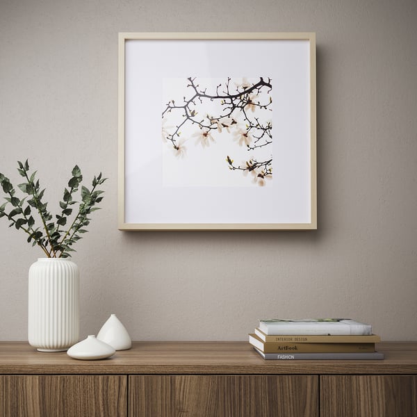 Minimalist decor: floral art, shelf with vase, design books, small object.