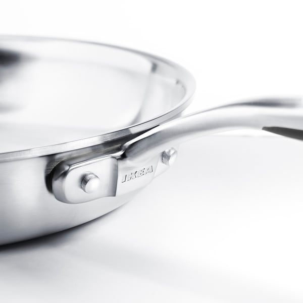 Stainless steel frying pan with ergonomic handle, showing premium craftsmanship.