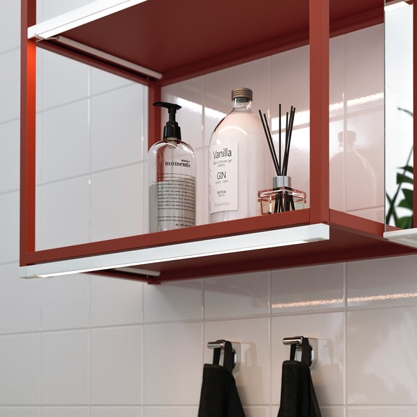 Bathroom shelf with led lighting, illuminating toiletries and towels.