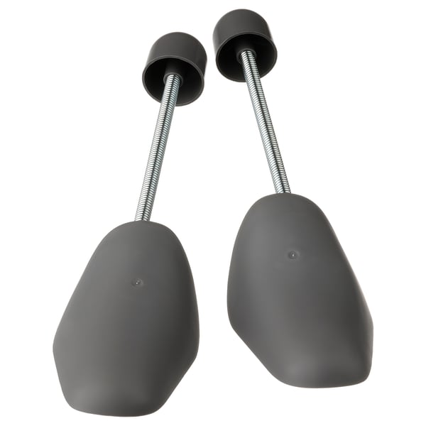 Two grey shoe shapers with flexible metal connectors, designed to maintain shoe shape.