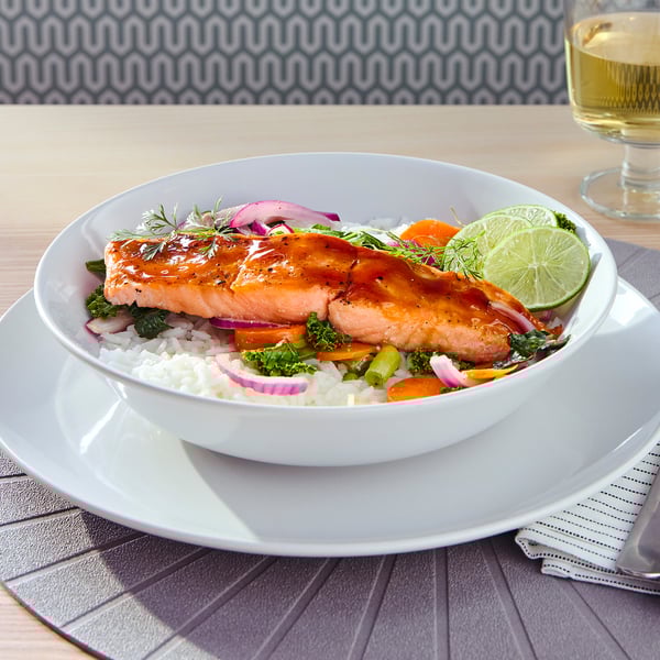 Plate of glazed salmon atop rice, veggies, and lime, likely representing a cooked and served SJÖRAPPORT dish.