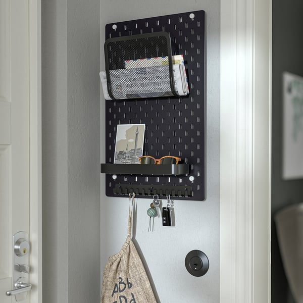 Black wall-mounted pegboard organiser with mail slot, keys, and bag, ideal for home office or entryway.