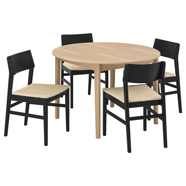 SKANSNÄS: round wooden dining table and chairs. Light wood with four black chairs. Woven seat design.
