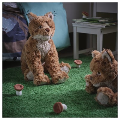Soft cuddly toy lynx, brown and white, round body, pointed ears, black tip tail, soft material.
