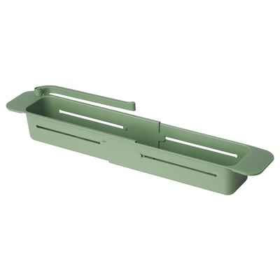 Depicts a green SKOLÄST kitchen sink organiser, featuring slots for brushes and a dishcloth holder.