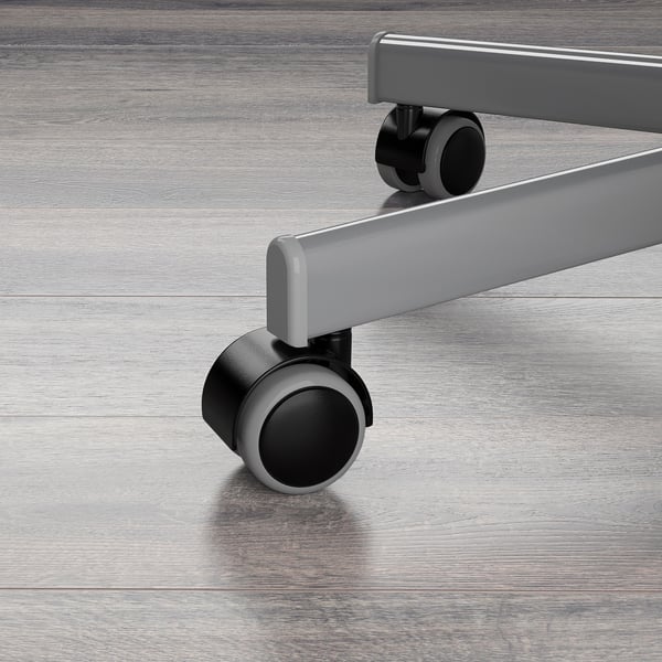 Close-up of office chairs sturdy, adjustable base and smooth, rubber-coated castors on wooden floor.