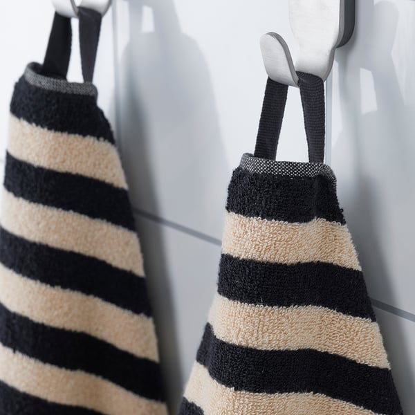 Two striped towels hang neatly on hooks, showcasing their absorbent and stylish design.