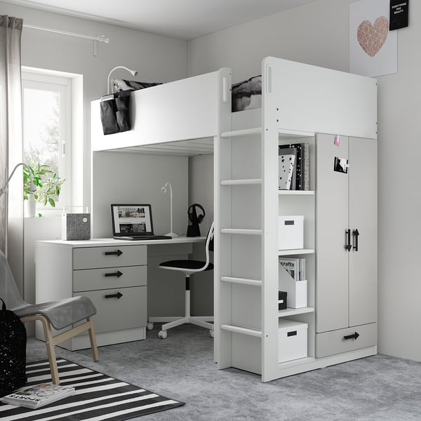 Modern kid’s room with white SMÅSTAD loft bed, desk, and wardrobe. Grey carol rug, wooden chair, and minimalist decor.