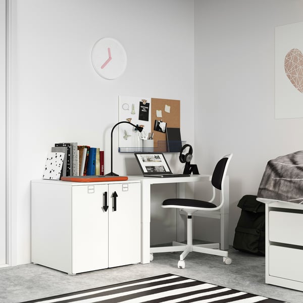 Modern home office with white SMÅSTAD cabinet, chair, and desk, featuring a laptop, books, and clock.