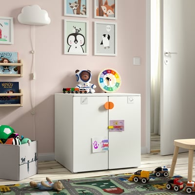 Childs room with white cabinet, toys, books, clock, stool, & rug road design.