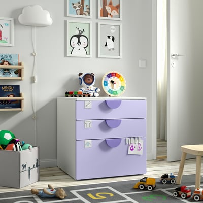 Kids room with lilac SMÅSTAD drawers, toys, clock, and astronaut.