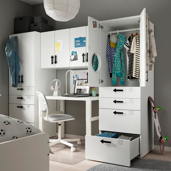 Modern kids room with white SMÅSTAD furniture: wardrobe, desk, and shelves. Clothes and toys organised, soccer-themed bedding.