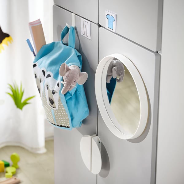 A playful, blue, kids backpack with a giraffe design hangs on a white, circular hook attached to a grey, modular wardrobe unit.