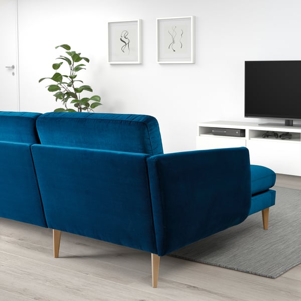 Modern living room with large blue SMEDSTORP sofa, wooden legs, cushions, tv stand, and wall art. Sofa matches rooms minimalist design.