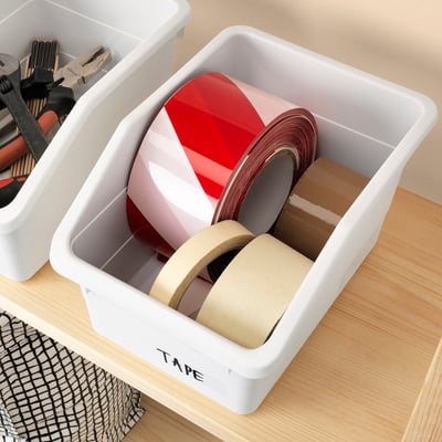 White organiser box holds rolls of tape and tools, labelled tape for easy identification.