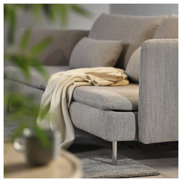 Modern grey sofa bed with light legs, cosy pillows and blanket.