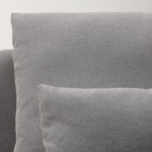 Grey upholstered sofa detailed view, soft fabric, deep cushions.