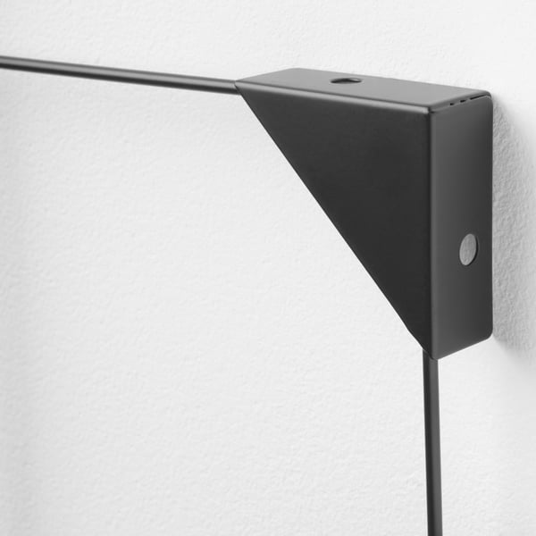 Dark metal memo board mounted on a light wall, showcasing a sleek, modern design with a sturdy clip and mount.