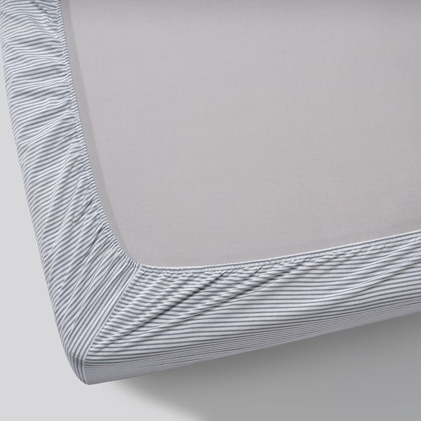 A fitted sheet with blue striped edges, neatly covering a mattress.