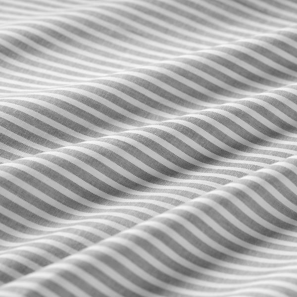 Close-up of striped bedsheet in black and white, showcasing intricate texture and stitching quality.