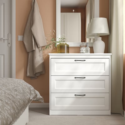 White chest of drawers, three drawers with handles, simple design.