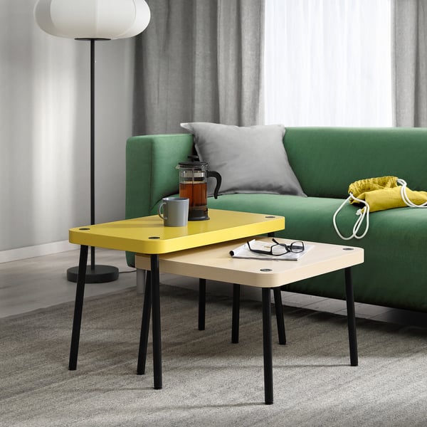 Bright yellow SONHULT nesting tables, modern design, small size in living room setting.