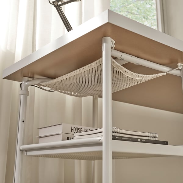 Desk with adjustable shelves and cable management net, holding books and notebooks.
