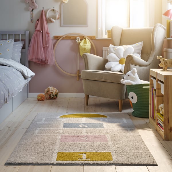 STÄPPSPARV rug, grey, rectangular, soft, fits under chair, with books nearby.