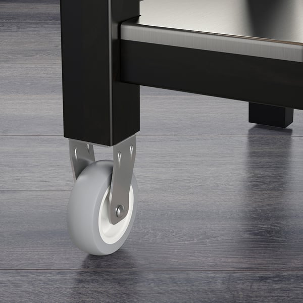 Close-up of trolleys sturdy black metal leg with a smooth, grey wheel for easy movement. Quality materials and craftsmanship are evident.