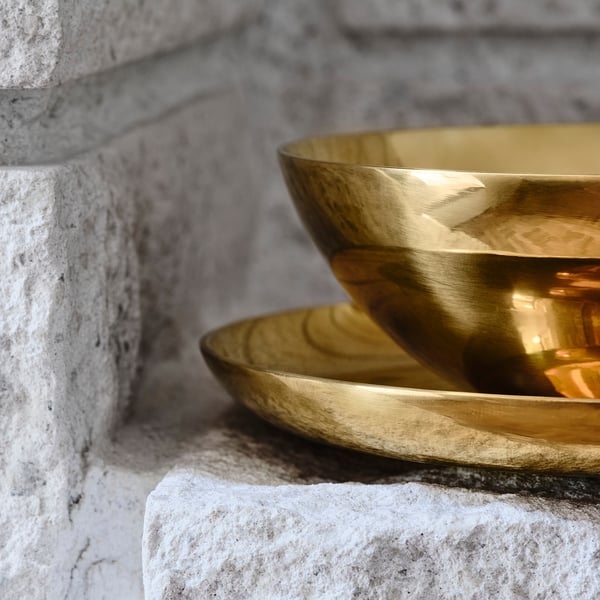 Stainless steel bowl in rock, reflecting light.