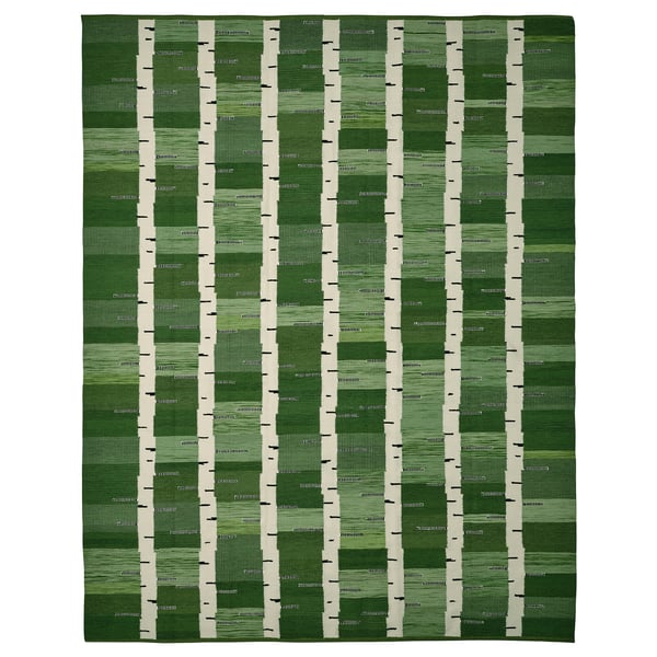 A green handwoven reversible wool rug with a birch tree pattern, part of the stockholm collection.