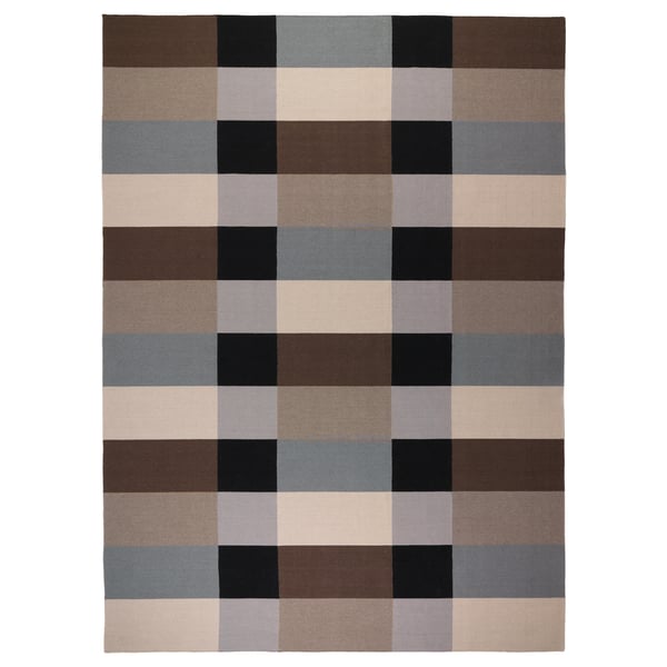 A brown, multicoloured chequered rug named STOCKHOLM, handwoven in wool, featuring a bold pattern and rectangular shape.