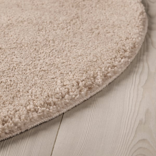 Close-up of a velvet textured rug on wooden floor, showcasing its thick, soft pile and subtle sheen.