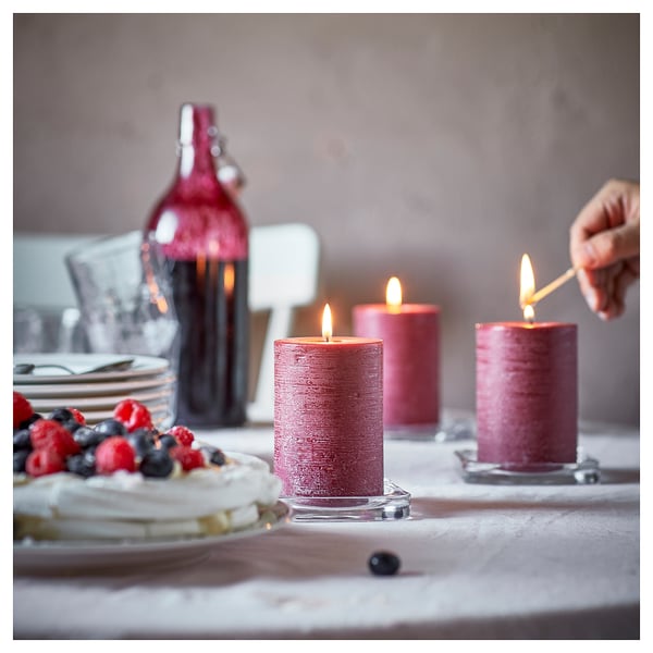 Pink candles lit on table with cake; candle dreams.