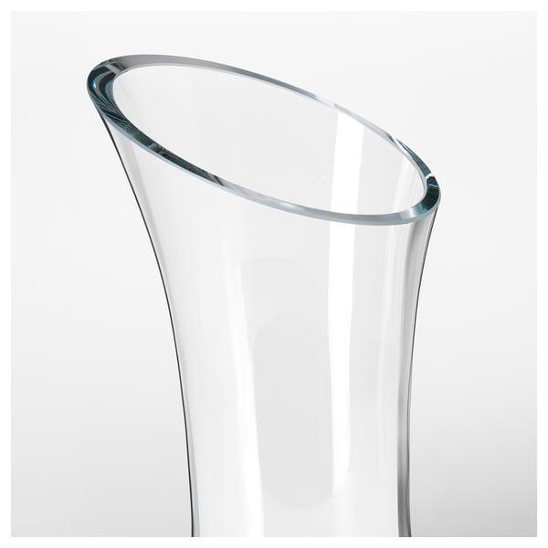 Clear, elegantly curved glass carafe, mouth-blown by a skilled artisan, showcasing its unique craftsmanship.