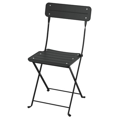 A black SUNDSÖ folding chair. Its made of steel and plastic, designed for small spaces. Its sleek, simple look makes it both practical and stylish.