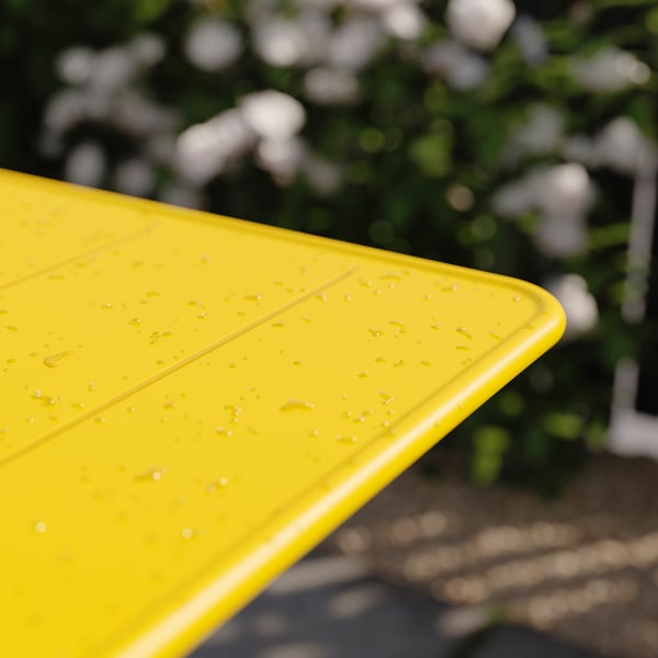 Bright yellow foldable outdoor table with water spots, partial view, outside.