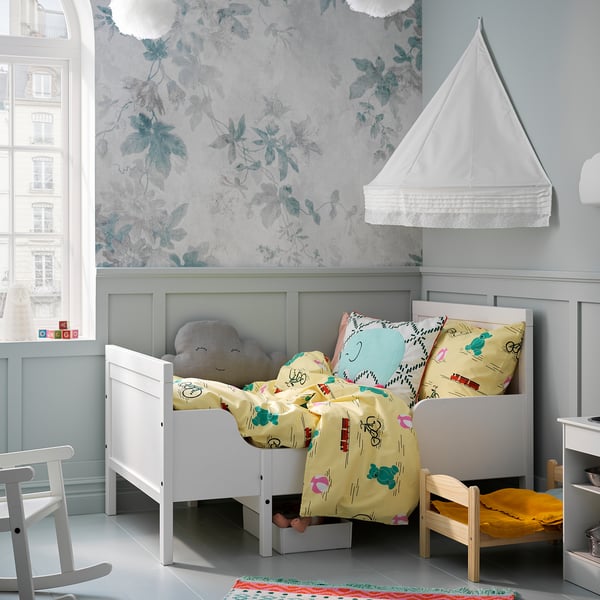 Kids room with white SUNDVIK bed, yellow bedding, floral wallpaper, and grey walls.