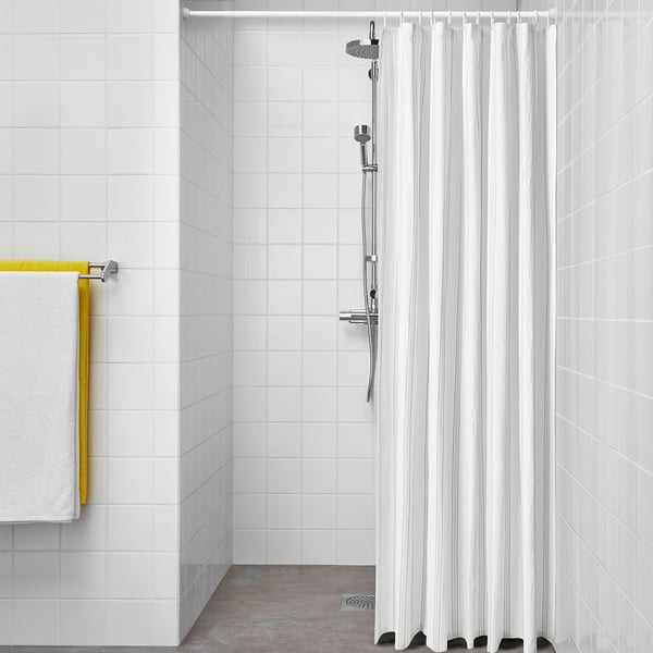 SVARTSTARR shower curtain: white, recycled polyester, striped, floor-length, fits in bathroom corner, surrounded by tiles.