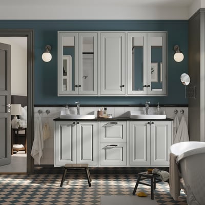 Modern grey bathroom cabinets, double sink, wall-mounted, dark green walls, checkerboard floor, round lights, towels, stool.
