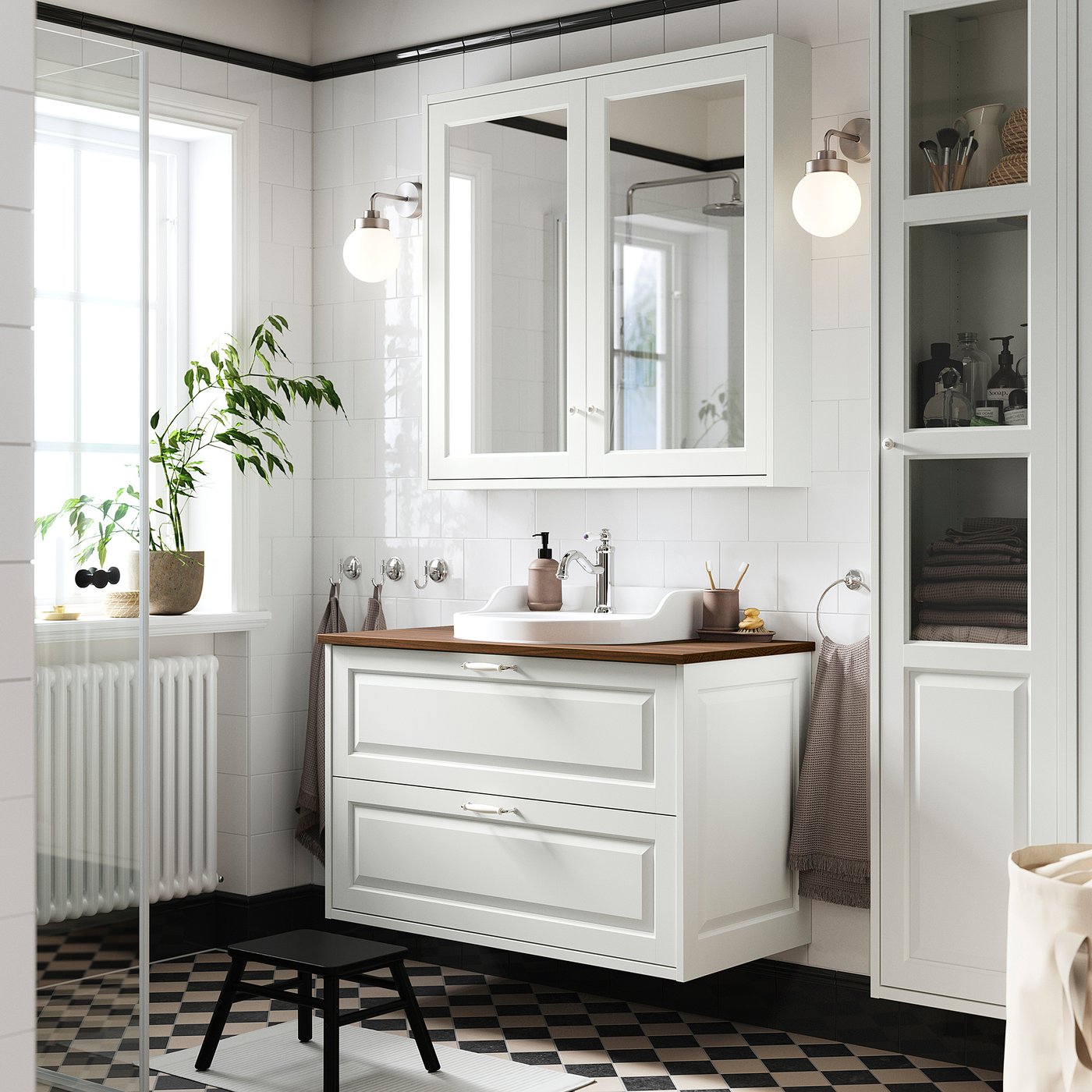 Modern white bathroom vanity with wooden countertop, mirrored cabinet above, and black floor tiles.