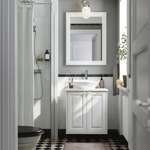 Small white TÄNNFORSEN vanity in bathroom with sink, mirror, and shower.