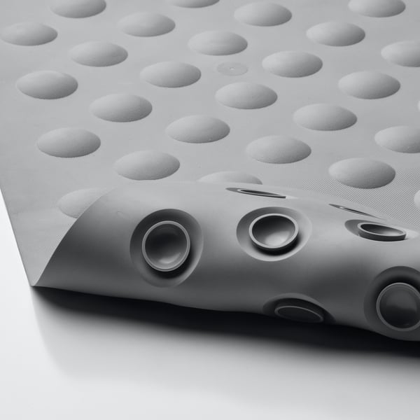 Grey shower mat with suction cups. Textured surface for grip. Holes for hanging.