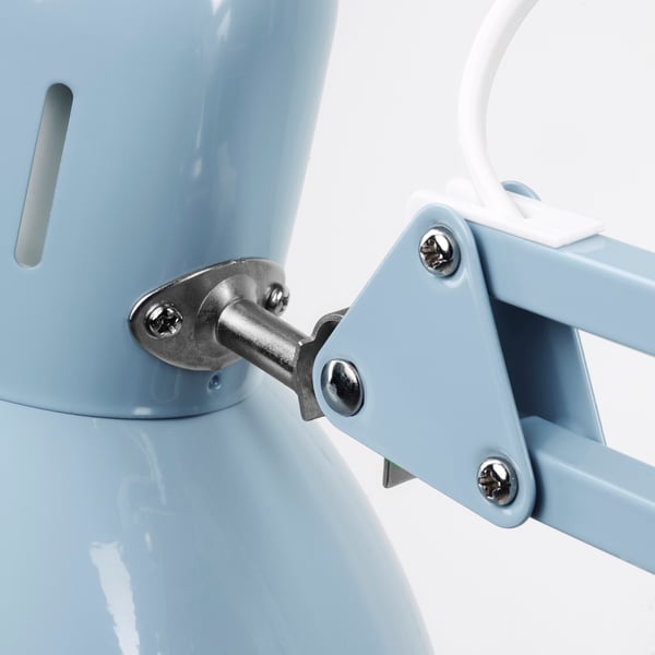 Close-up of a sturdy, light blue metal lamps adjustable joint, showing screws and metal hinge for stability.
